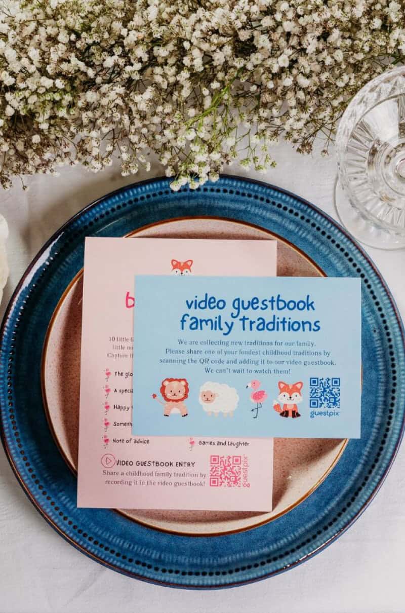 Allestimento del tavolo per la festa di benvenuto al neonato con cartellino con codice QR Guestpix per condividere le foto di famiglia durante l'evento.
