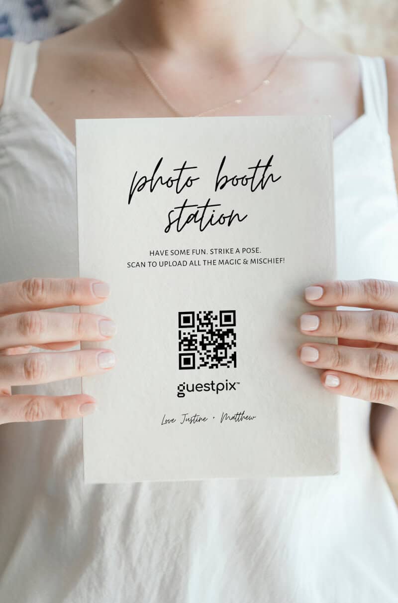 Panneau pour photomaton de mariage avec code QR permettant aux invités de scanner et de télécharger leurs photos, se distinguant par une élégante police manuscrite et un design minimaliste.