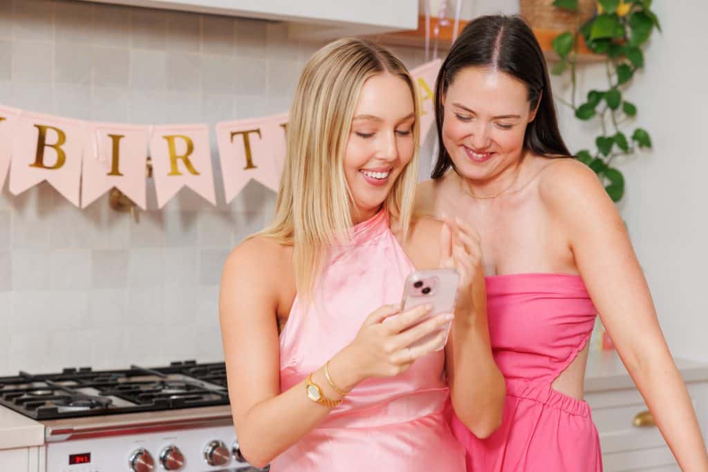 Happy women enjoying birthday celebration taking photos using a QR code event photo sharing platform.