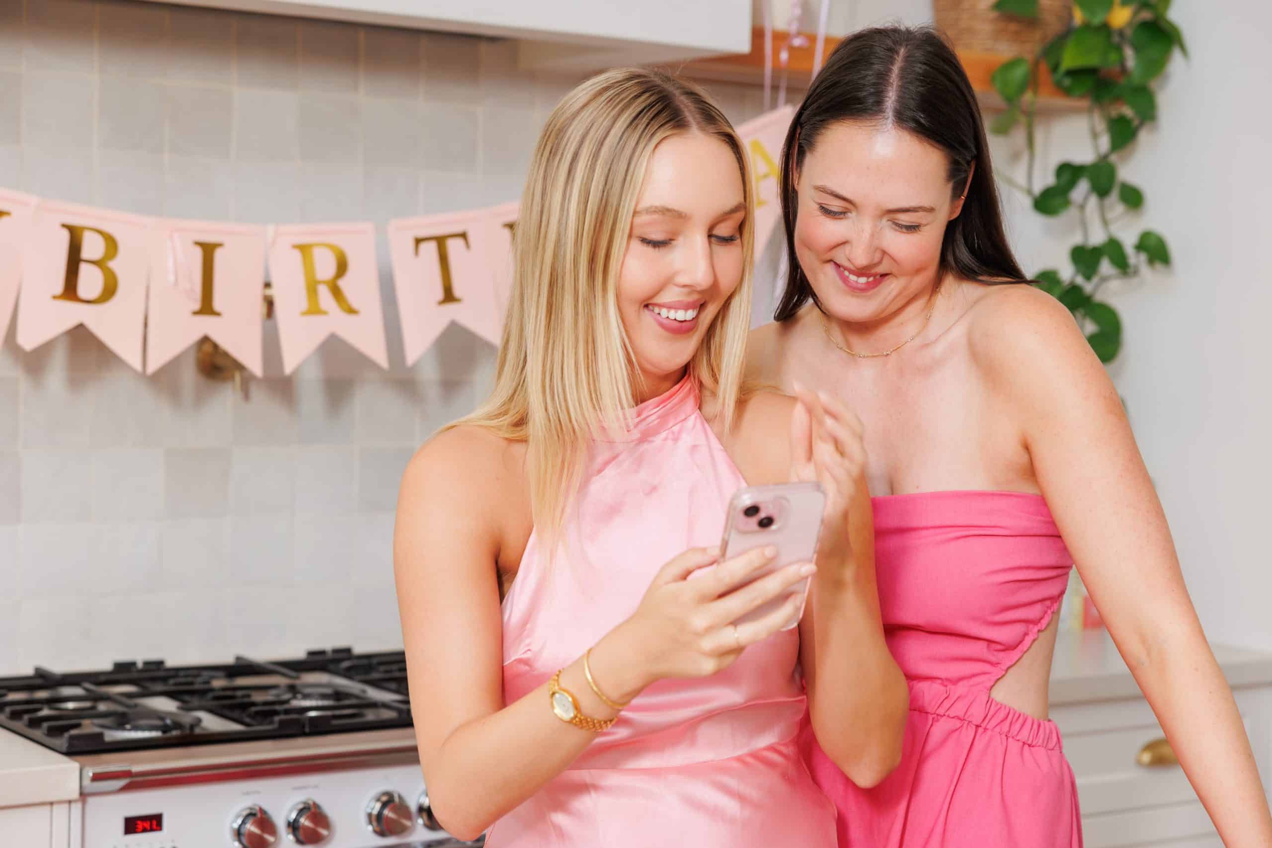 Girls at birthday party using smartphone for photo sharing with QR code platform. - GUESTPIX | #1 QR Code Event Photo Sharing Platform Happy women enjoying birthday celebration taking photos using a QR code event photo sharing platform.