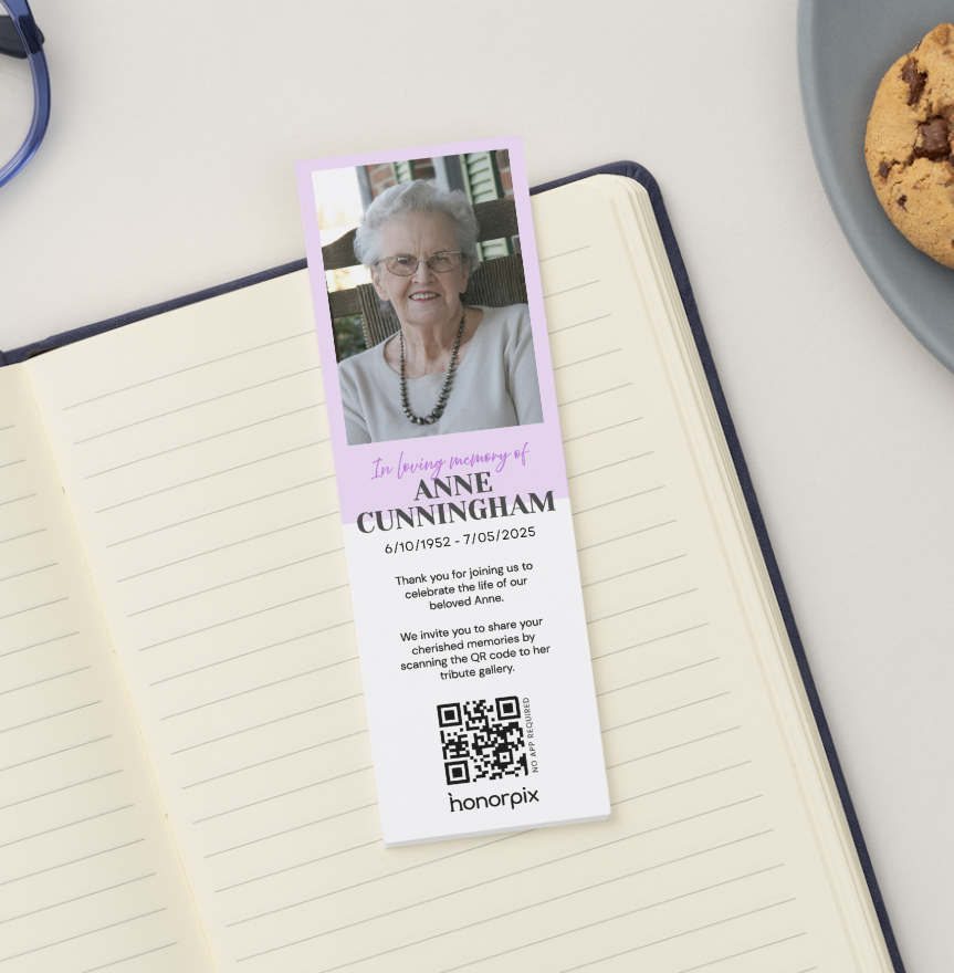 Marcapáginas conmemorativo con un retrato de Anne Cunningham, la inscripción «En memoria de...» y las fechas, además de un código QR en la parte inferior.