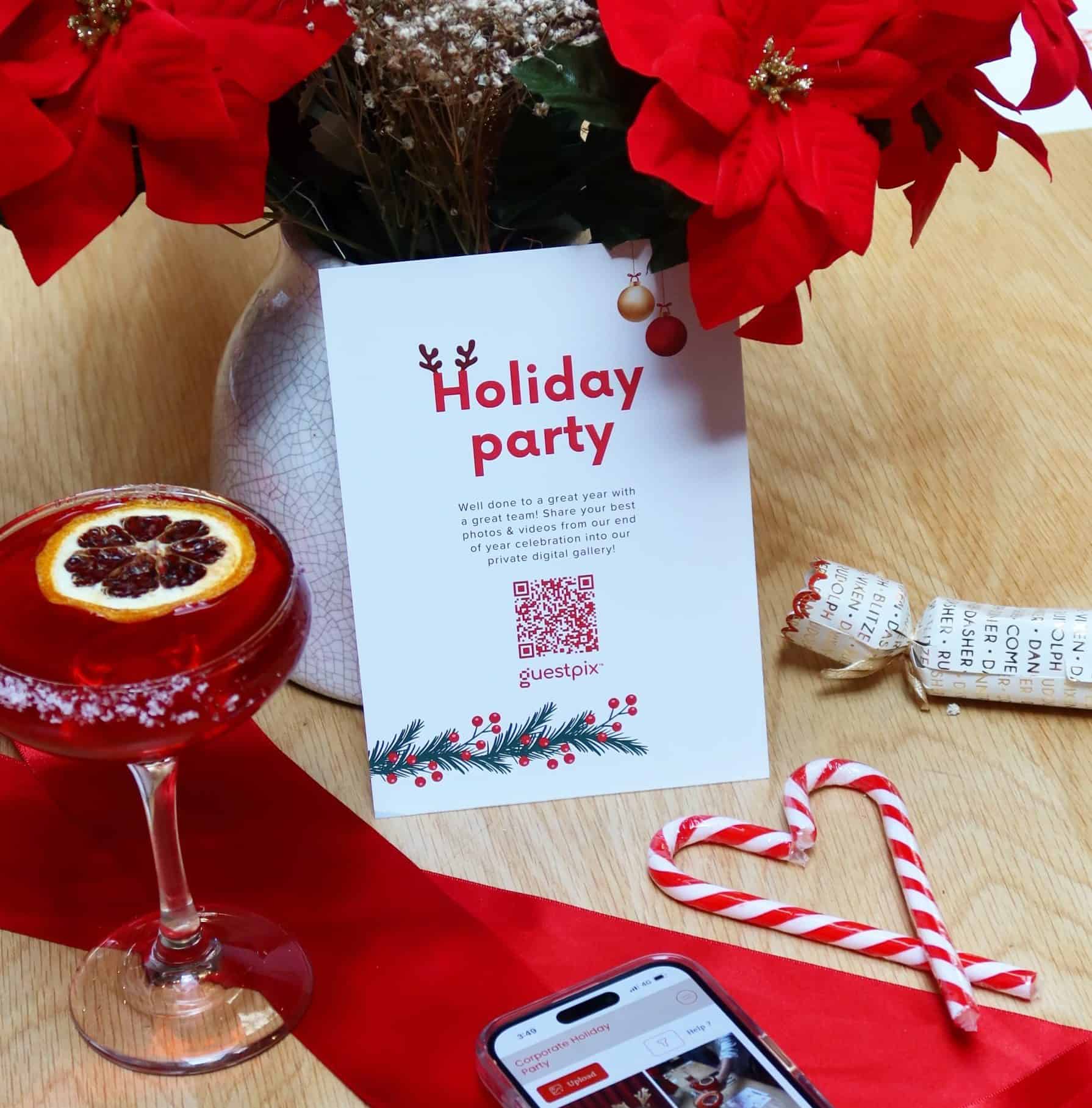 Bouquet di stelle di Natale rosse in un vaso di ceramica, con un biglietto di auguri natalizi, un nastro rosso, bastoncini di zucchero e una bevanda festiva su un tavolo di legno.