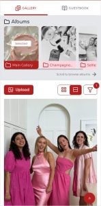 Vier Frauen in rosa Kleidern posieren und lächeln in einem hellen Raum mit einer weißen Tür und Kunstwerken im Hintergrund.