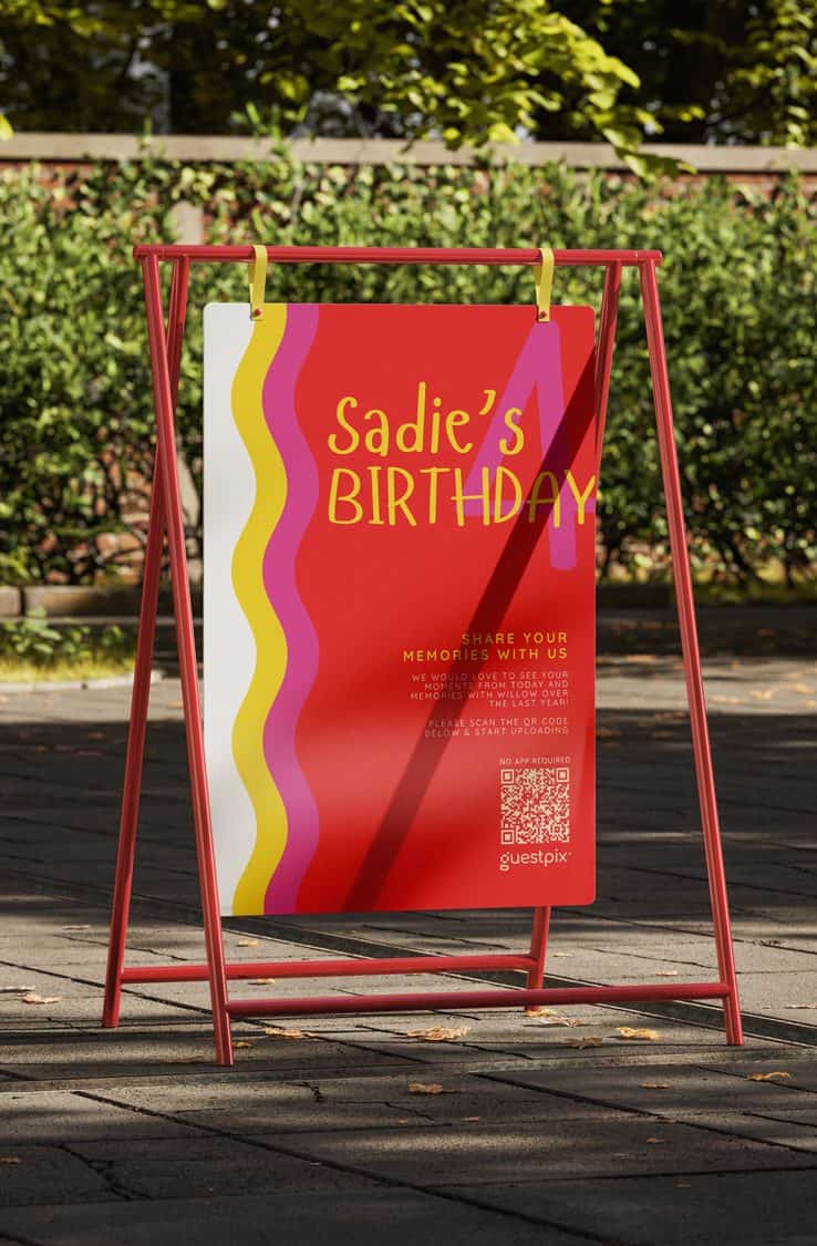 Cartel colorido para celebrar el cumpleaños de Sadie, con llamativos motivos ondulados y los detalles del evento, colocado al aire libre sobre un soporte rojo.