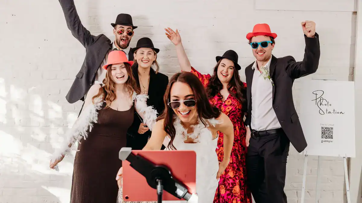 Los invitados a la boda disfrutan de una cabina de fotos DIY de GUESTPIX™ 