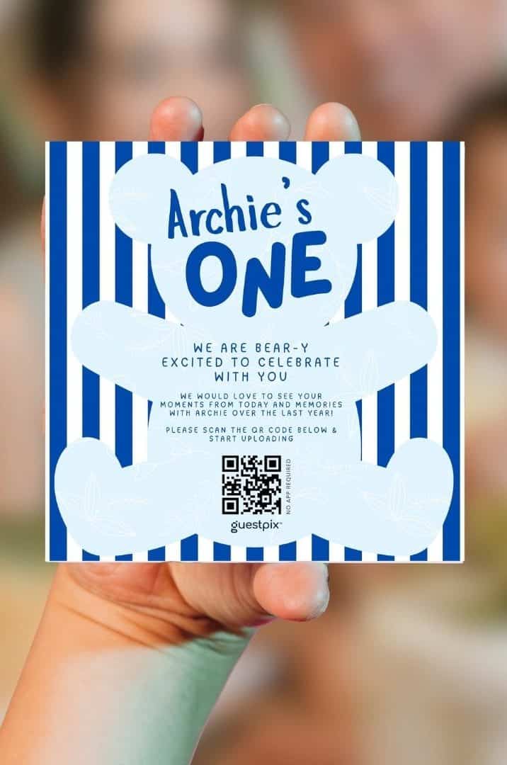 青いストライプとクマのモチーフをあしらい、アーチーの1歳の誕生日パーティー用に名前入りメッセージを添えた招待状。イベントへの参加用QRコードも記載されています。