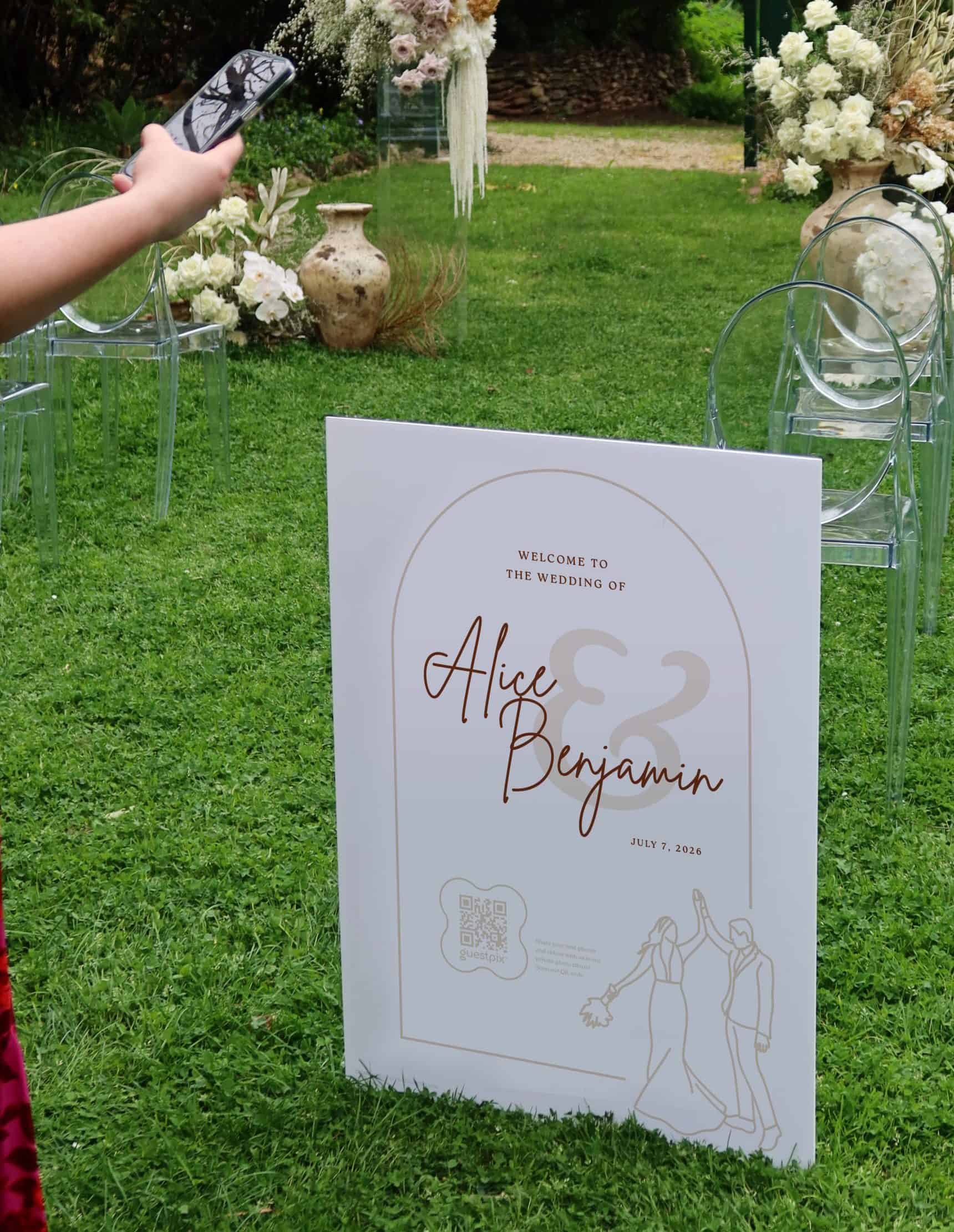 結婚式での写真共有用に、カップルのイラスト、QRコード、パーソナライズされた名前が入ったウェディングサイン。