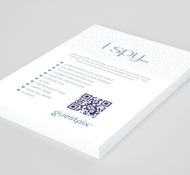 Folleto blanco con un diseño geométrico azul, características enumeradas con viñetas y un código QR destacado junto al logotipo de Guestpix sobre un fondo claro.