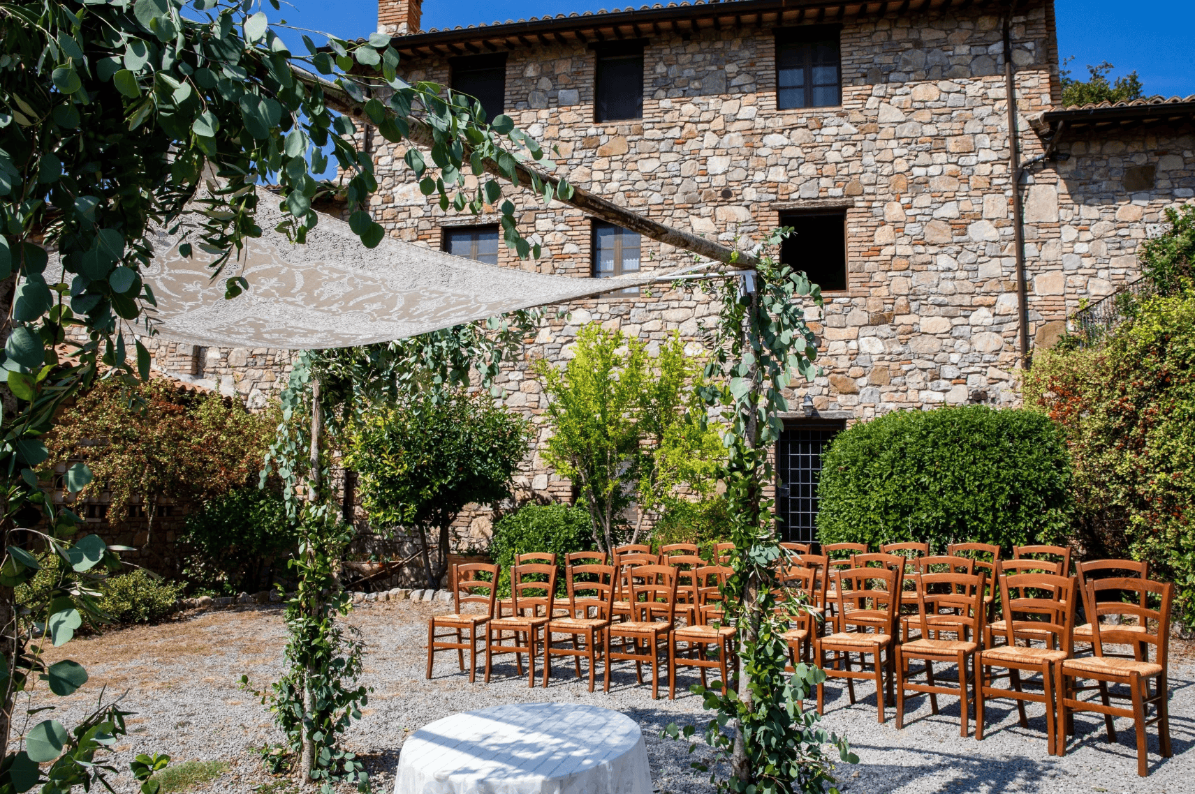 Charmant lieu de mariage en plein air avec un coin salon et un bâtiment rustique en pierre