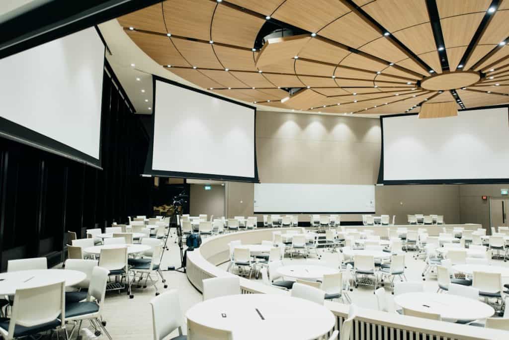 Profesionales del mundo empresarial estableciendo contactos en un evento corporativo luminoso y moderno.