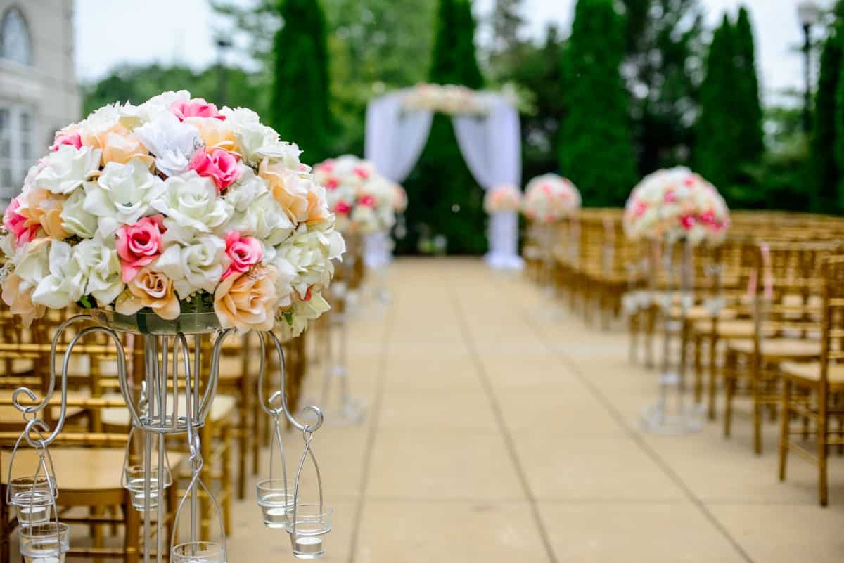 Elegant Wedding Cake Cutting at Sunset - GUESTPIX | #1 QR Code Event Photo Sharing Platform Elegant wedding cake cutting celebration under warm outdoor sunset lights.