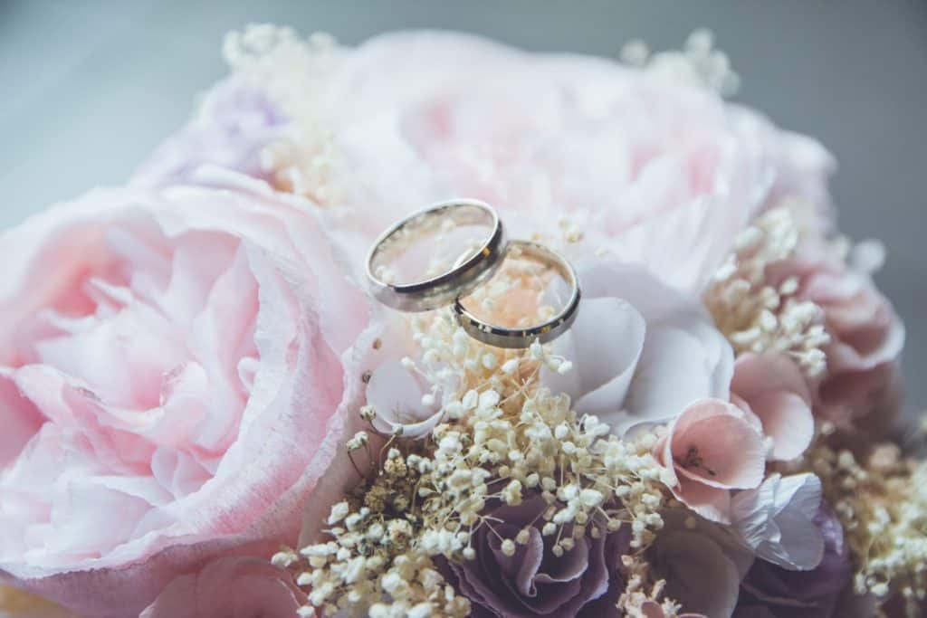 Elegante papelería para invitaciones de boda sobre una mesa con flores.