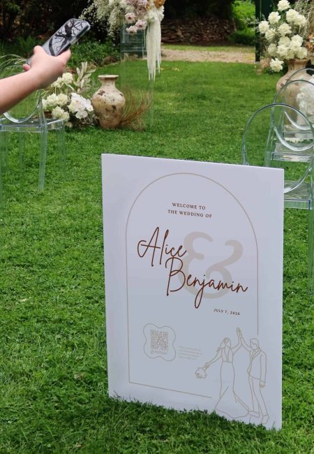 Wedding sign featuring couple illustration, QR code, and personalised names for event photo sharing at a wedding.