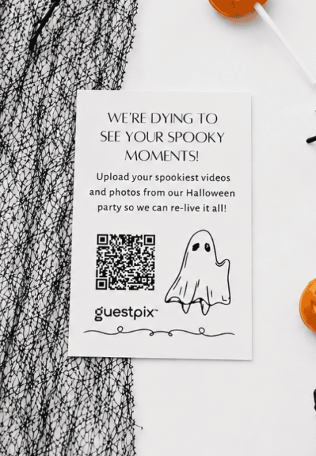 Halloween-themed flyer inviting guests to upload spooky moments; features a QR code, a ghost illustration, and the guestpix logo.