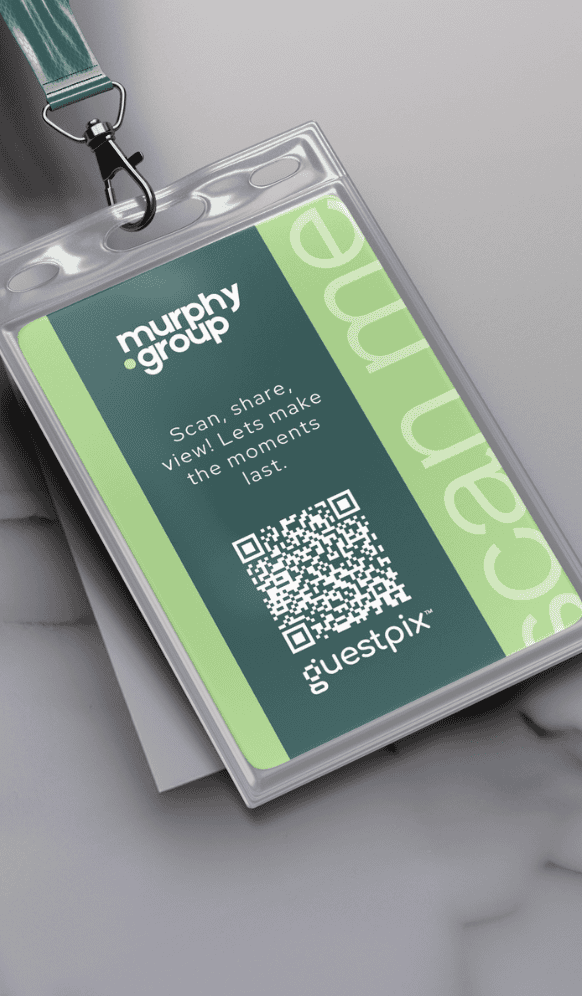 Ein Veranstaltungsausweis aus Kunststoff an einem blaugrünen Umhängeband mit dem Logo der Murphy Group, einem grünen Feld mit einem Gastfoto und einem QR-Code?