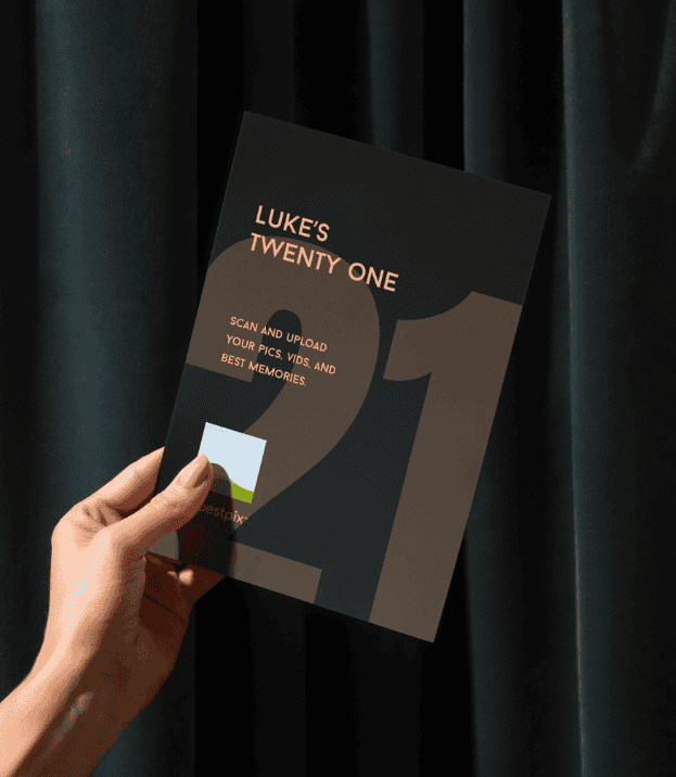 Una mano que sostiene un folleto oscuro titulado «LUKE'S TWENTY ONE», con un gran «21» y una pequeña miniatura de una foto, con unas cortinas oscuras como fondo.