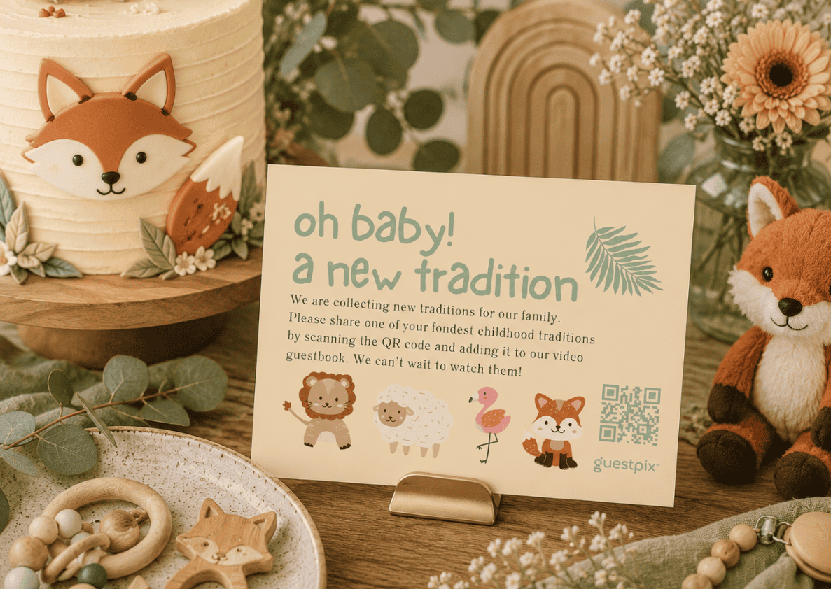 Décoration pour une fête prénatale comprenant un gâteau couleur crème, un renard en peluche et une pancarte sur laquelle on peut lire « Oh baby ! Une nouvelle tradition », invitant les invités à partager leurs traditions à cette occasion.