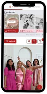 Phone screen displaying a photo gallery app with album thumbnails and a group of four women in pink dresses posing.