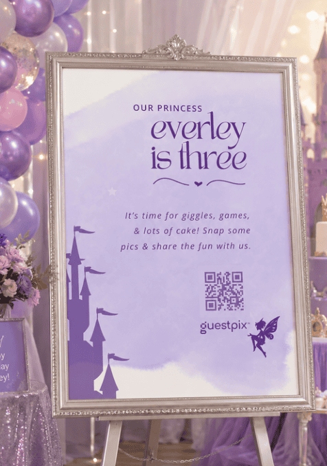 Cartello incorniciato con la scritta “La nostra principessa Everley compie tre anni” in un allestimento di compleanno viola con palloncini e sagome di castelli.