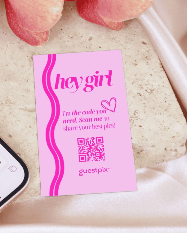 Biglietto rosa per gli ospiti con il logo “hey girl”, un cuore e un codice QR che invita a scansionarlo per condividere le foto.