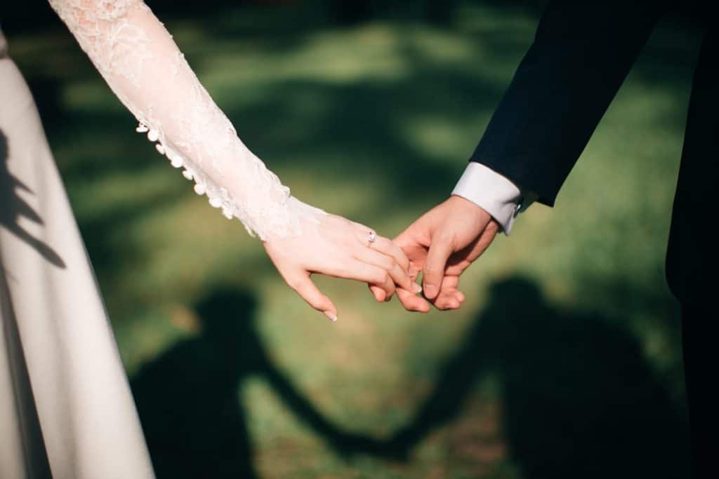 Un invitado a una boda que sostiene una cámara y está haciendo fotos en un banquete.